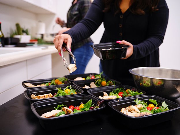 Person preparing portioned meals.