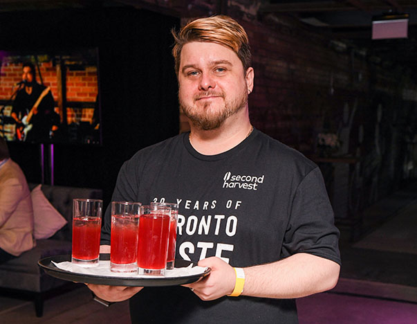 Person holding tray of drinks at an event.